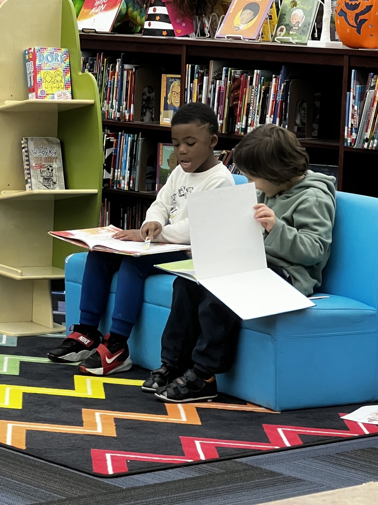 Two young boys reading in media class