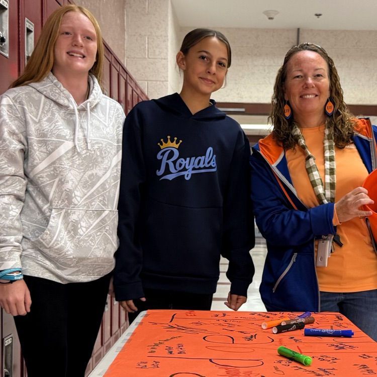 A picture of a teacher and student signing a pledge to end the R word
