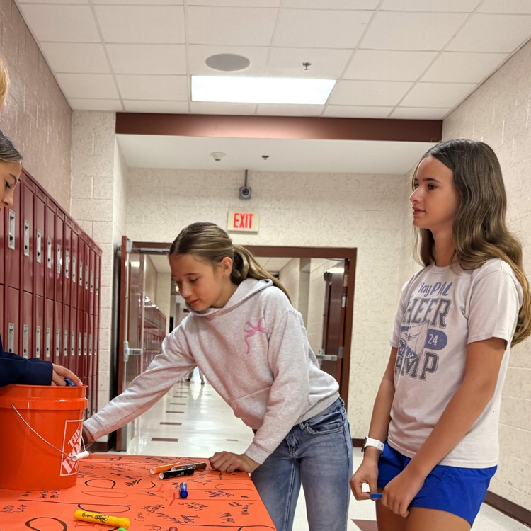 A picture of a teacher and student signing a pledge to end the R word