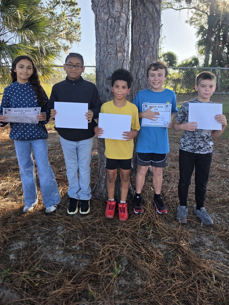 Five students, holding certificates, stand in a row with a tree in the background.