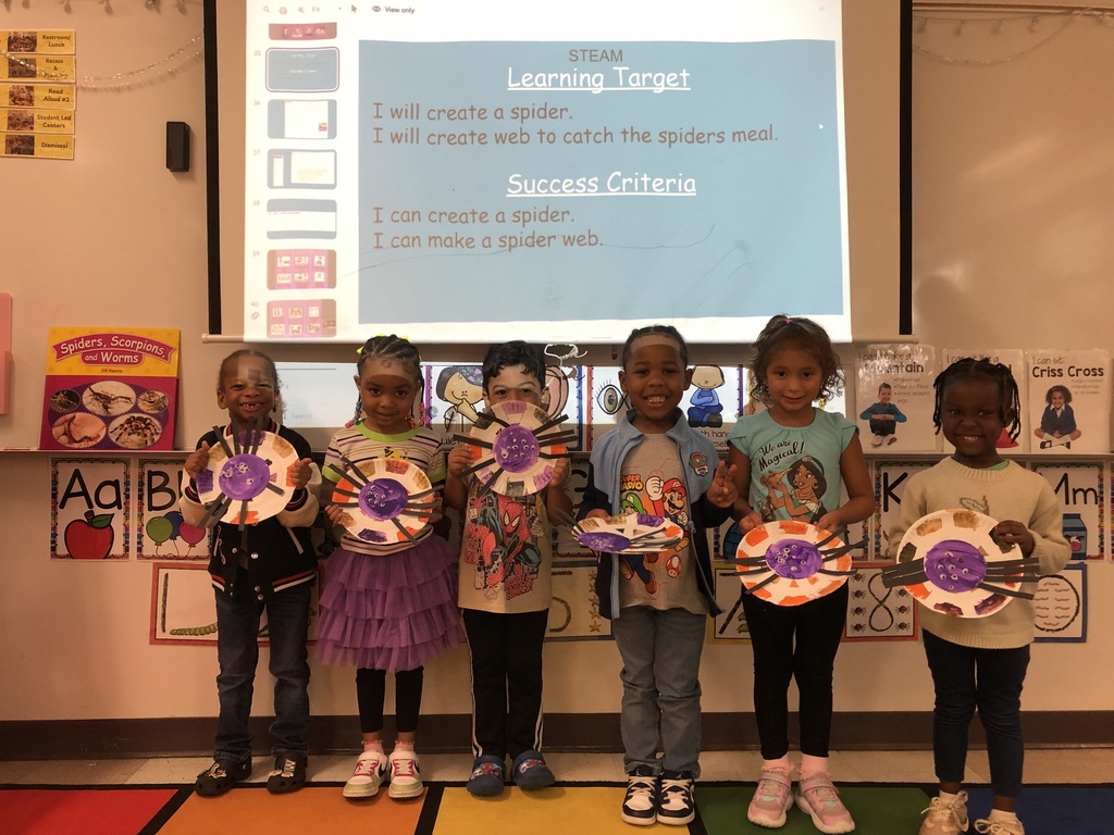 Pk students holding spider web creations