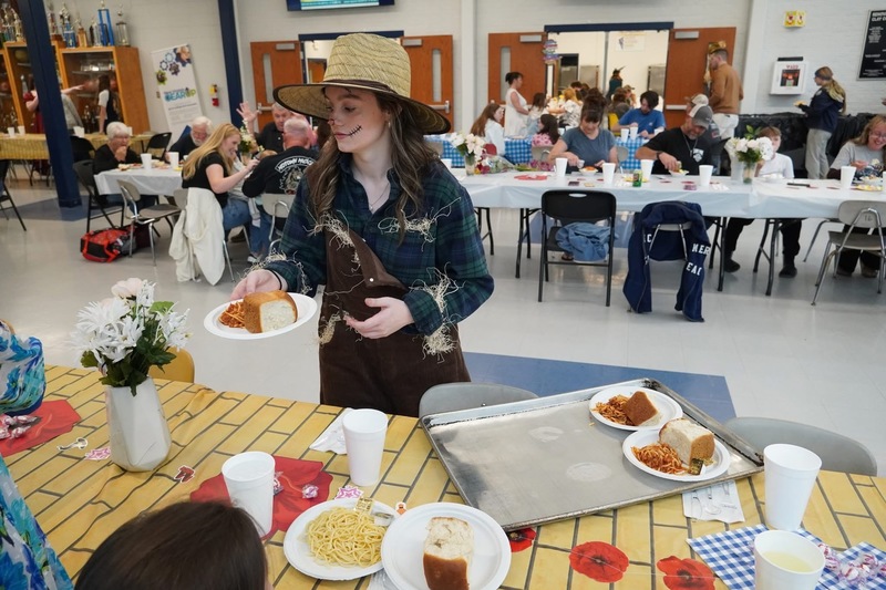 Students serving dinner before play
