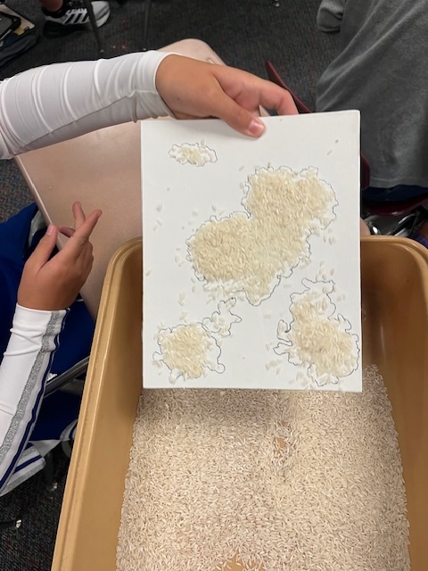 To better understand geographical features, Mr. Seuser's 7th grade geography class created rice maps. Students poured rice on a canvas and traced the pattern it created. When they took the rice off, they were left with a makeshift landform. They then filled it in and added their own features. At the end, they were asked to identify the different features of each map. #celebrate379