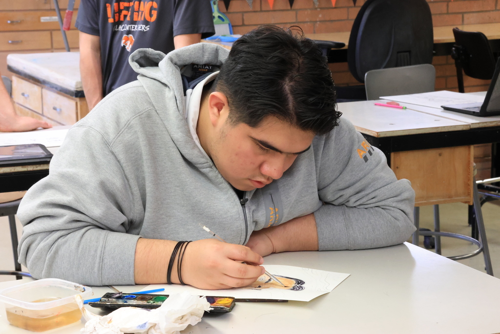 A student works on drawing his self portrait.