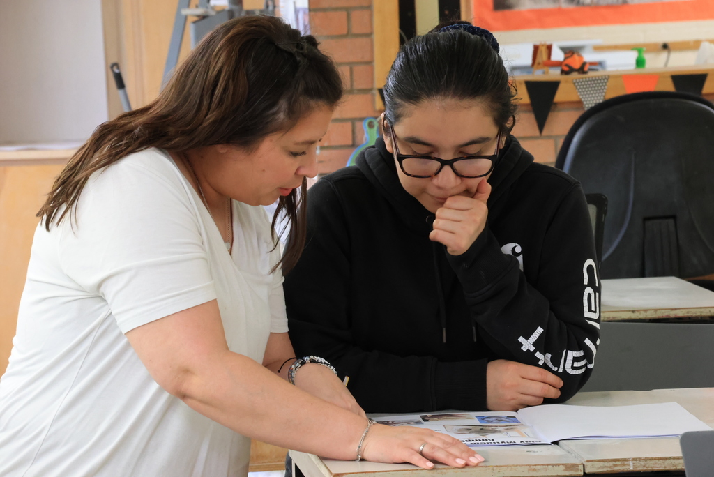 Mrs. Artman helps a student with her self portrait.