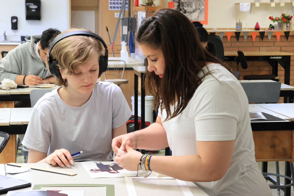 Mrs. Artman helps a student with her self portrait.