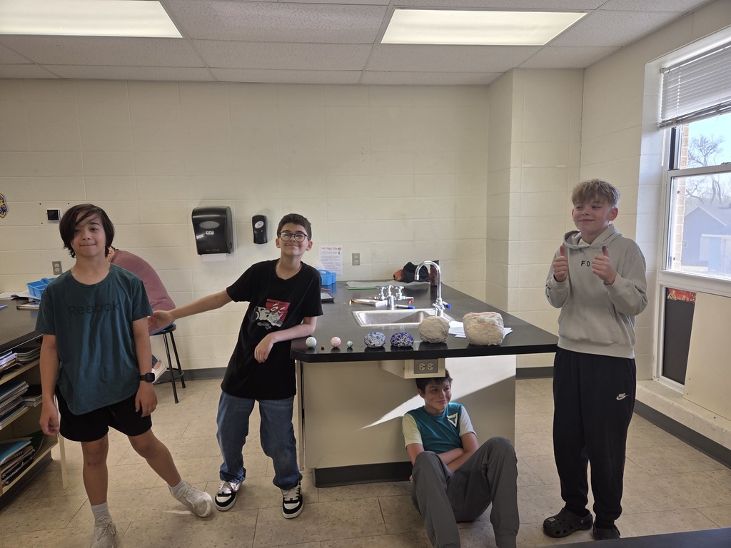 6th grade students in Mrs. Trembath’s science class display handmade scale models of the planets, created using materials like Styrofoam, tin foil, and toilet paper, as part of a solar system project that also incorporated math skills and percent error calculations.
