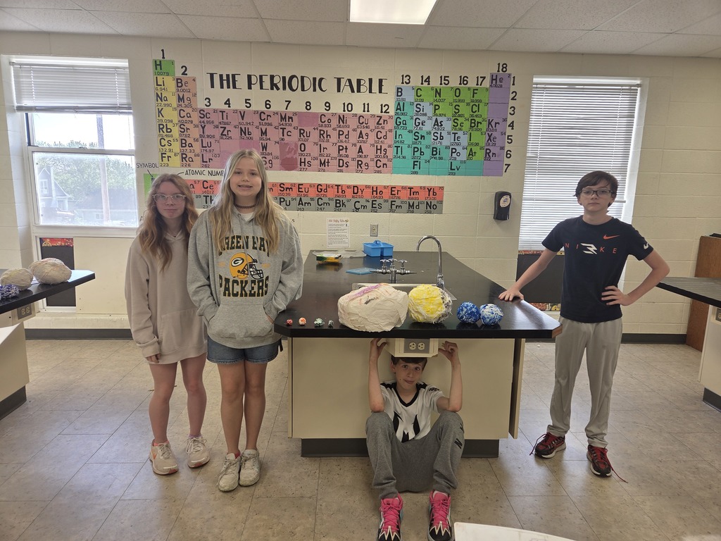 6th grade students in Mrs. Trembath’s science class display handmade scale models of the planets, created using materials like Styrofoam, tin foil, and toilet paper, as part of a solar system project that also incorporated math skills and percent error calculations.