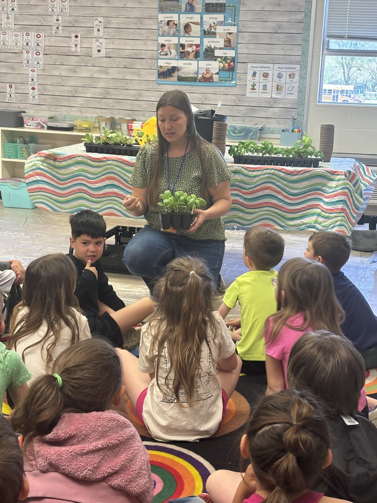 Mrs. Wisner talks to a group of first graders, showing them about what plants need to live and grown.