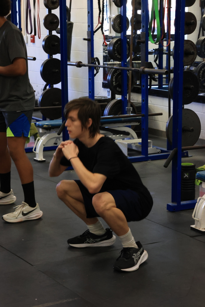 A student squat stretches in Mr. Freeman's strength and conditioning class.