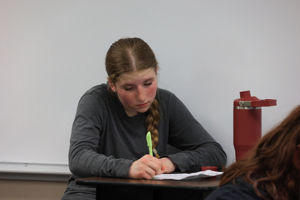 A student writes down answers to review questions in Mrs. Griffiths' math class.