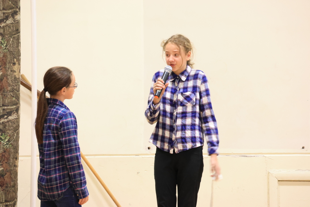 Students speak into the microphone during the play, 'Blame it on the Wolf."