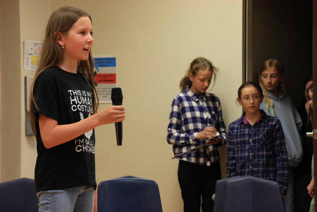 A student speaks into the microphone during the play, 'Blame it on the Wolf."