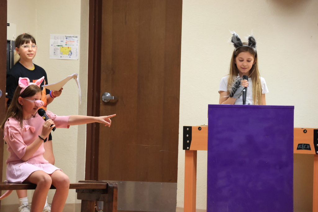 Students portray a pic and a wolf and talk with microphones during the play, 'Blame it on the Wolf."