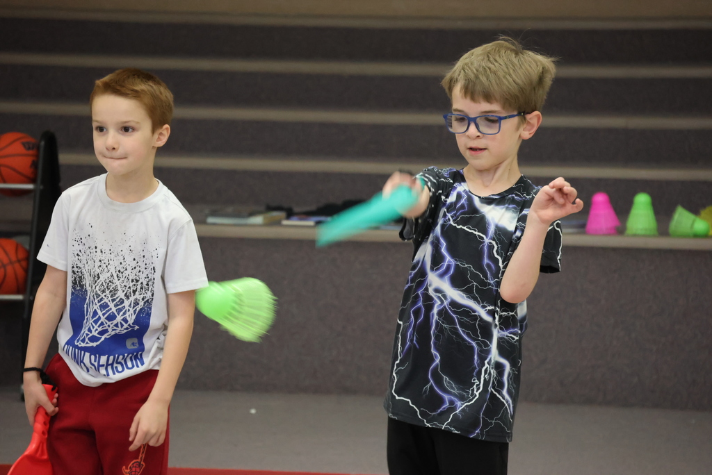 Mr. Beardsley's 2nd grade P.E. class practices holding and serving badminton birdies.
