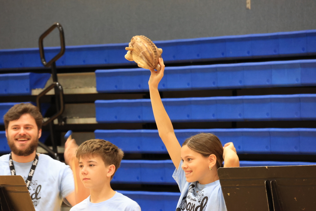 A student holds up her percussion instrument to the Wakefield students.