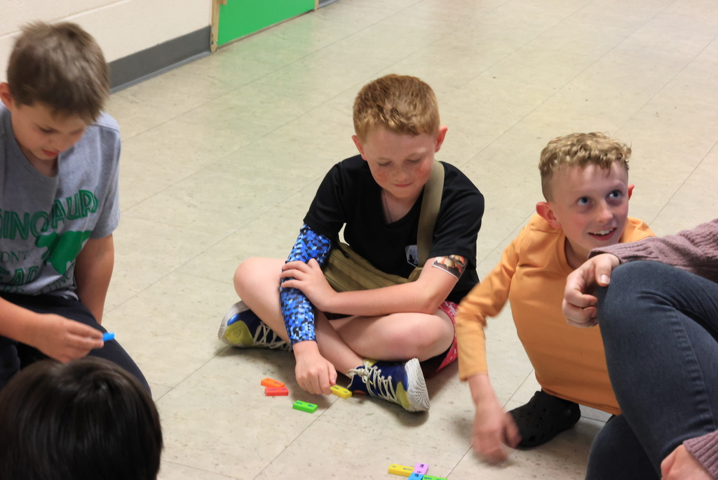 Students play a domino work prefix game in the hallway.