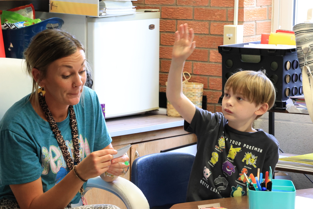 Mrs. Ehlers asks questions about a passage the students have read and a student raises his hand.