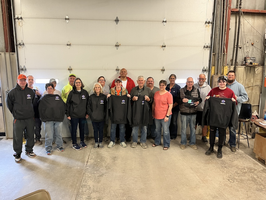 The USD 379 bus drivers pose for a group photo in the bus barn.