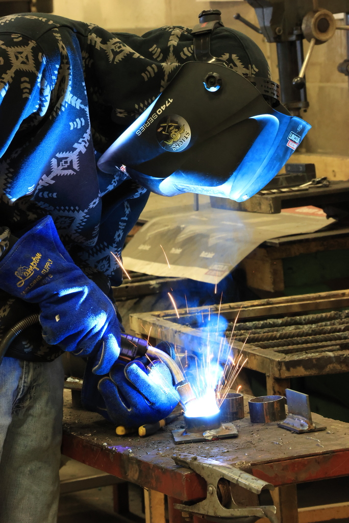 A student welds part of the billboard into place.