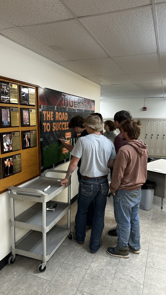 Students take turns signing "The Road to Success" board in the commons signifying where they will be attending school next year.
