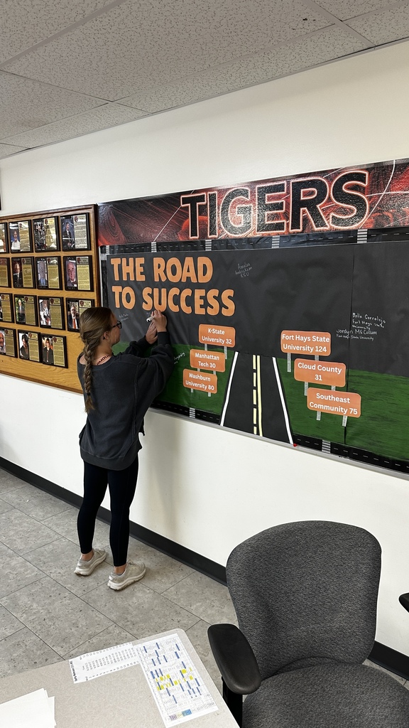 Students take turns signing "The Road to Success" board in the commons signifying where they will be attending school next year.