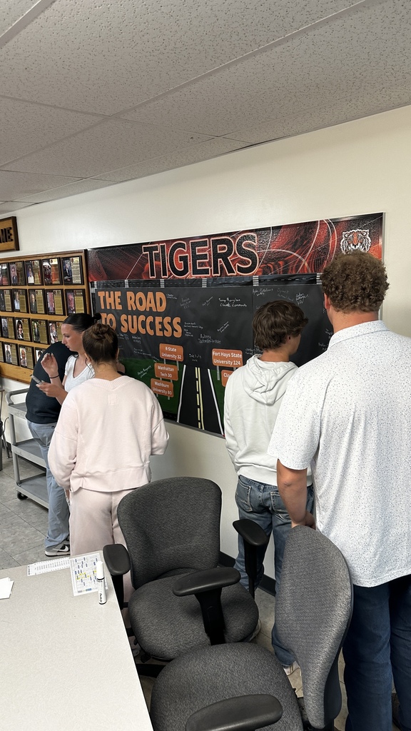 Students take turns signing "The Road to Success" board in the commons signifying where they will be attending school next year.