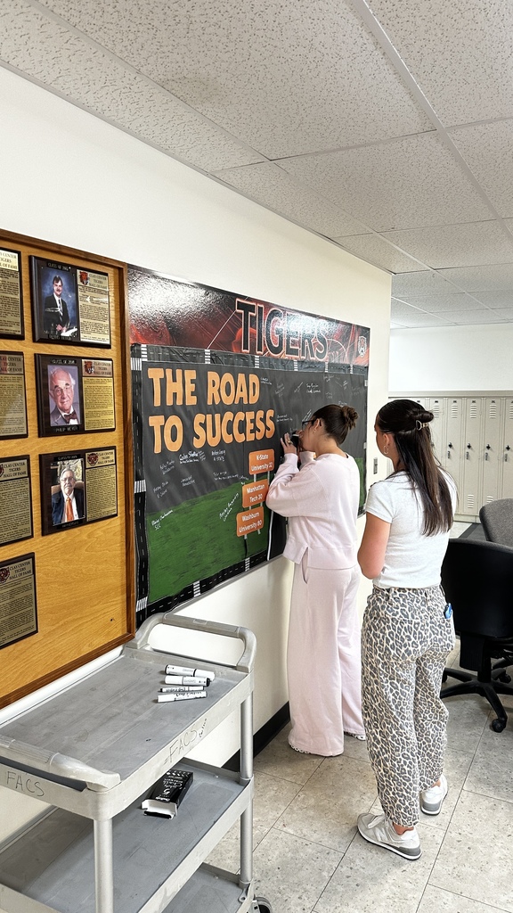 Students take turns signing "The Road to Success" board in the commons signifying where they will be attending school next year.