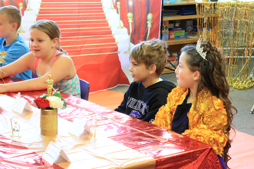 Students listen to readers during the class reading of their book.