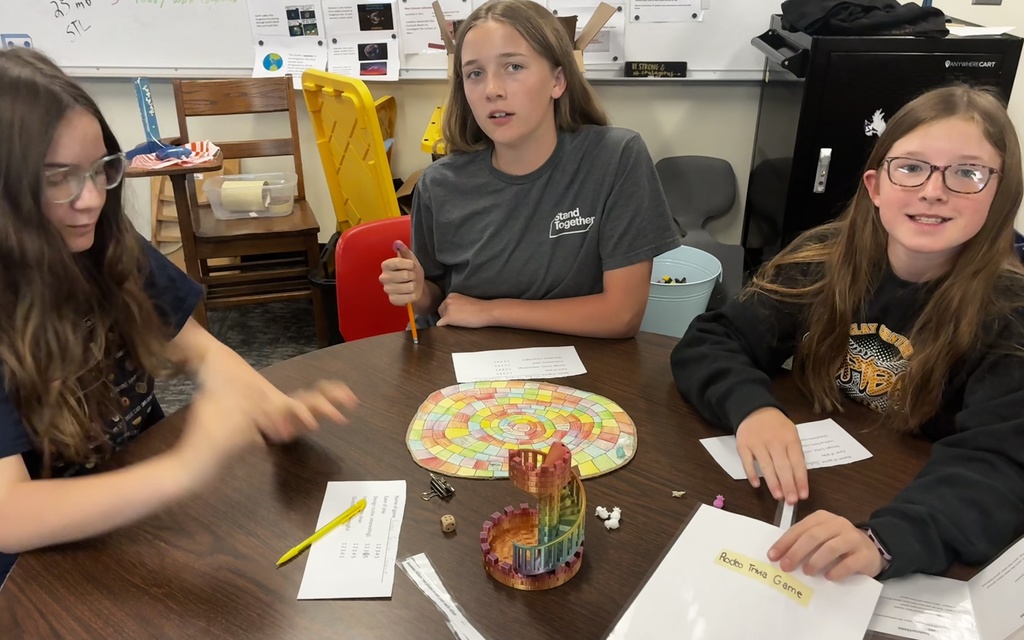 Students smile as they try out their review game that they created to prepare for end-of-year testing.