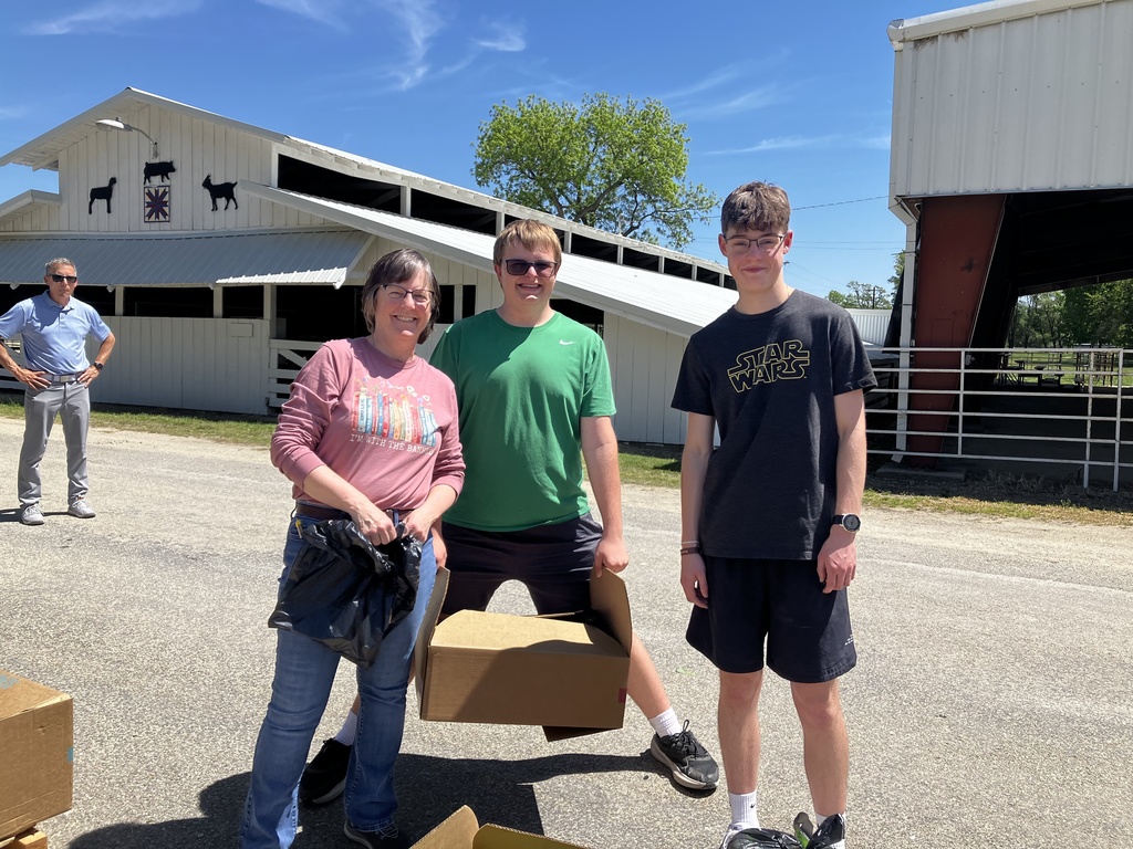Mrs. Reichert and NHS students help deliver food at the monthly Harvesters delivery service.
