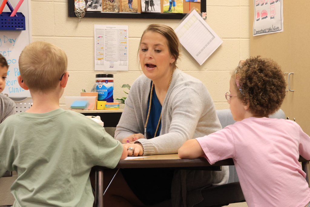 Mrs. Siebold works on handwriting with a group of kindergarteners.