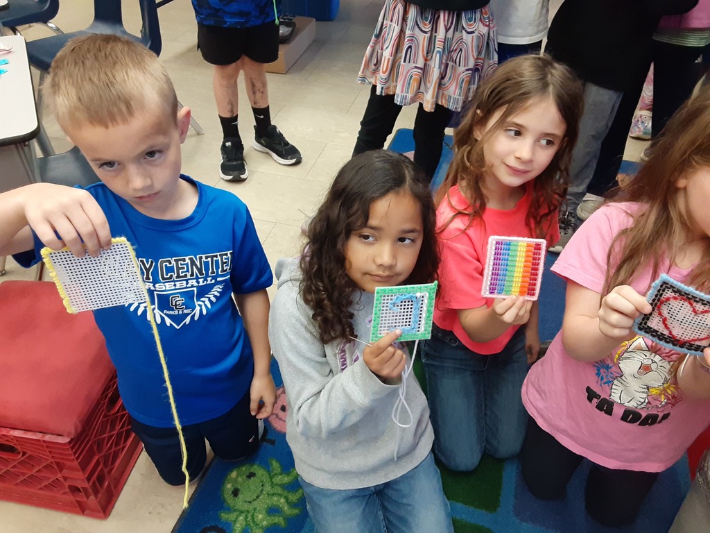 Members of Mrs. Carr's class show off their sewing canvas creations, which they have been working on as part of their soft start mornings.