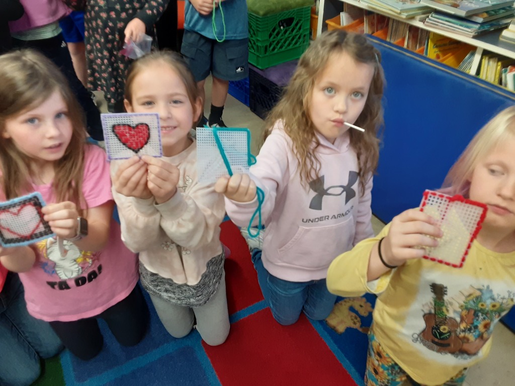 Members of Mrs. Carr's class show off their sewing canvas creations, which they have been working on as part of their soft start mornings.