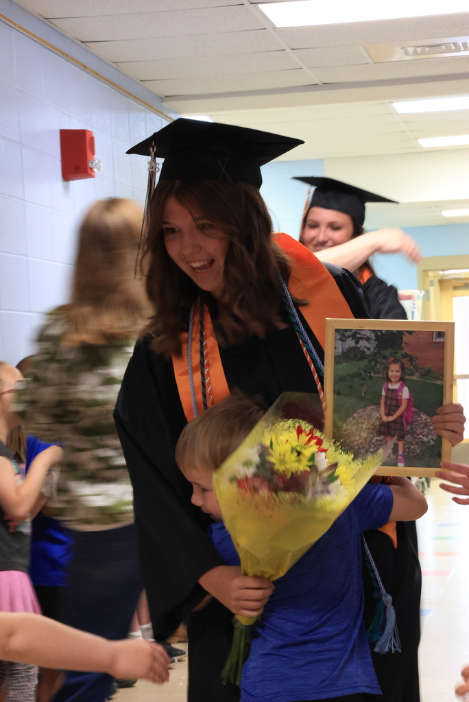 A senior gets hugs from students during the LES Graduation Walk.