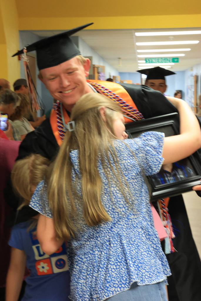 A senior gets hugs from his family during the LES Graduation Walk.