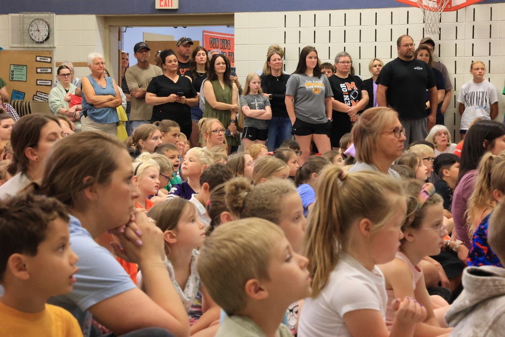 Senior family members and LES students listen to Mrs. Lane during the LES Graduation Walk.