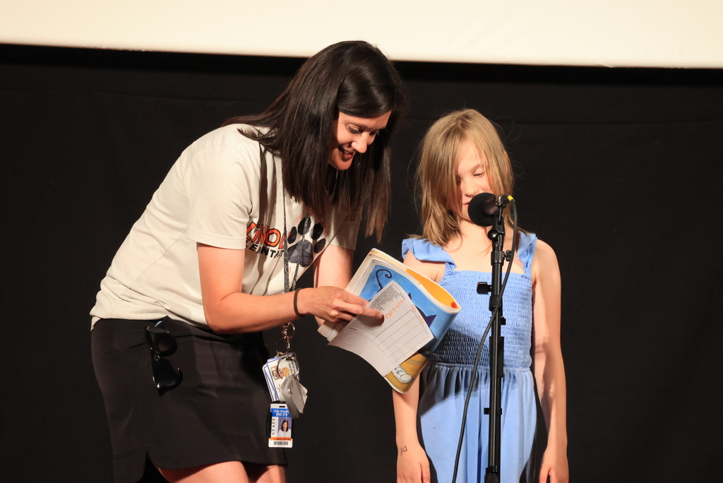 A student reads her poem with the help of Mrs. Graham