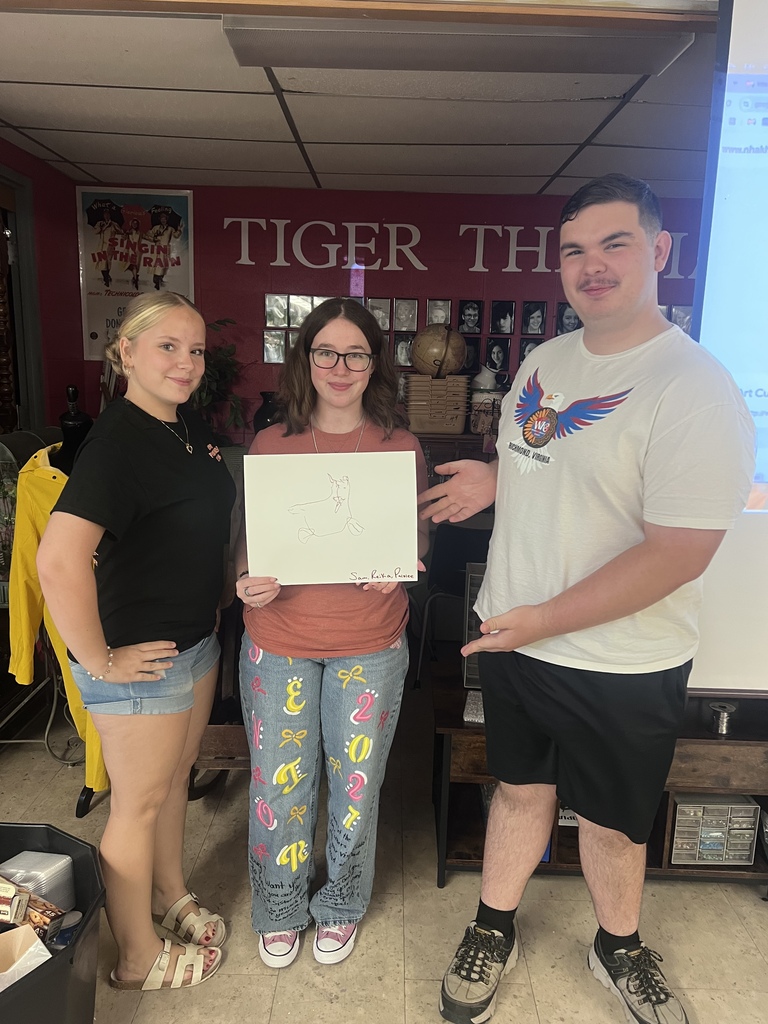 Mrs. Blackburn's debate team attempts to draw an image on the screen using teamwork with string and a marker.