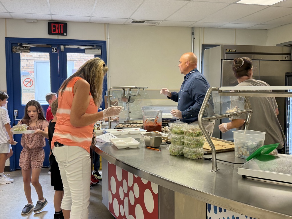 New principal Mr. Leis helps serve students food during lunch time.