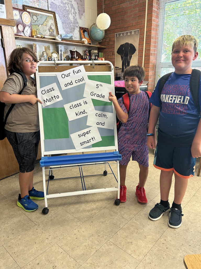 Mr. Yenni's students show off their new Class Mission Statement that they recite each morning. It says, "Our fun and cool 5th grade class is kind, calm, and super smart!"