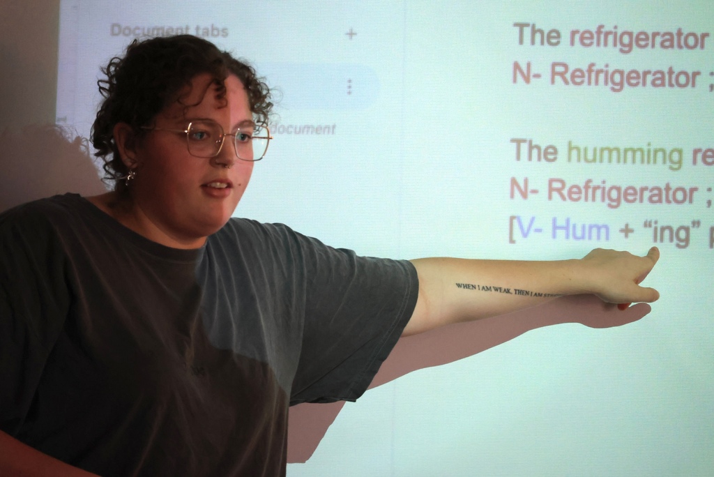 Ms. Smith teaches her 8th grade ELA students the definition of a participle while they write notes.