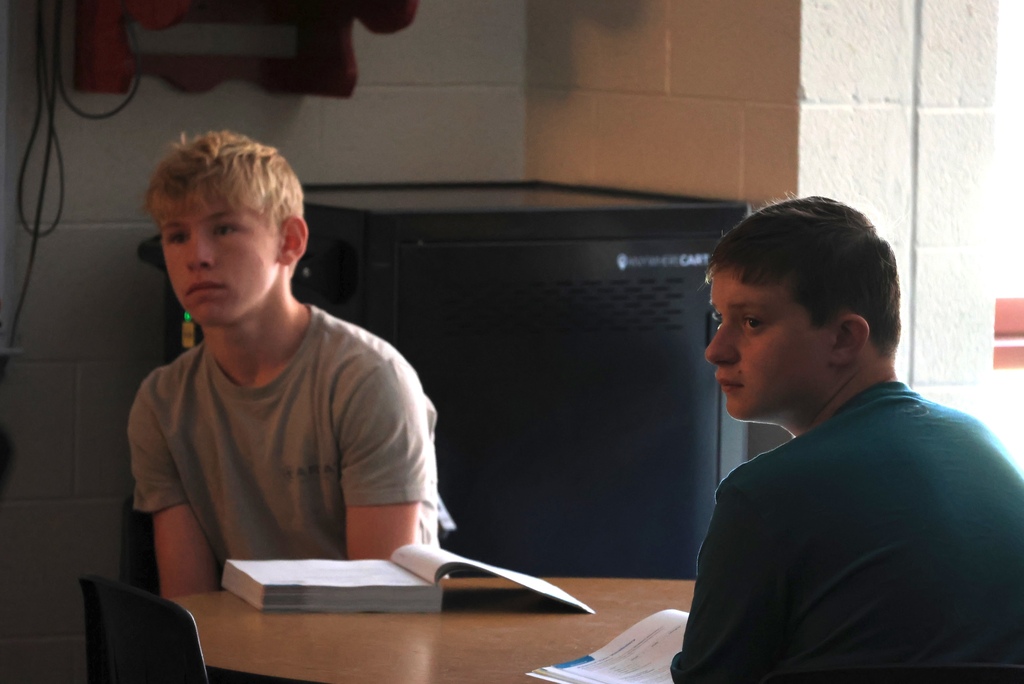 Ms. Smith teaches her 8th grade ELA students the definition of a participle while they write notes.