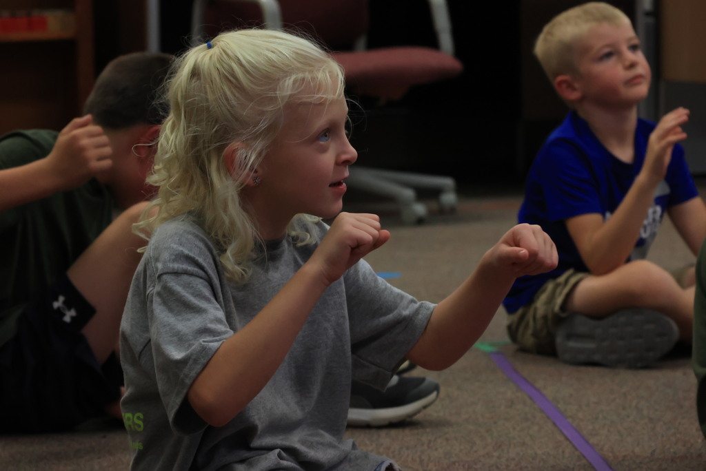 Mrs. Rourke has her students practice rowing a boat, then they grabbed a circular "rope" and rowed together to learn rhythm and move to the beat! 