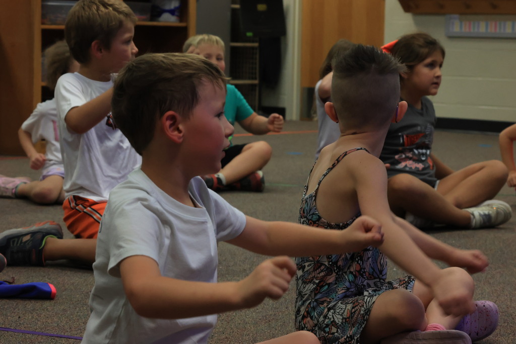 Mrs. Rourke has her students practice rowing a boat, then they grabbed a circular "rope" and rowed together to learn rhythm and move to the beat! 