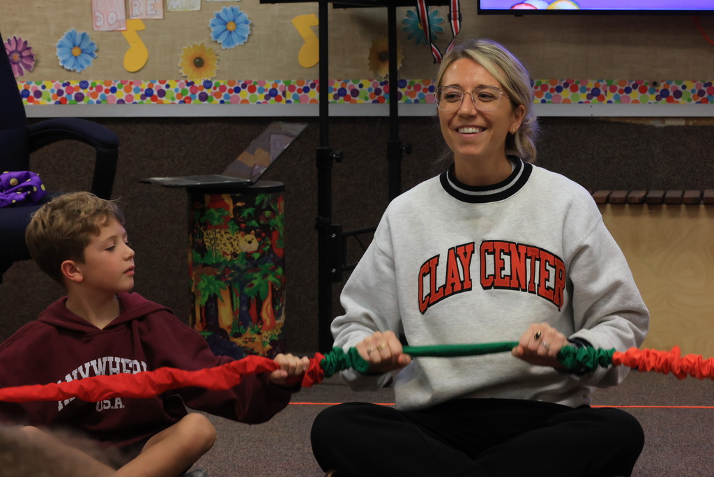 Mrs. Rourke has her students practice rowing a boat, then they grabbed a circular "rope" and rowed together to learn rhythm and move to the beat! 