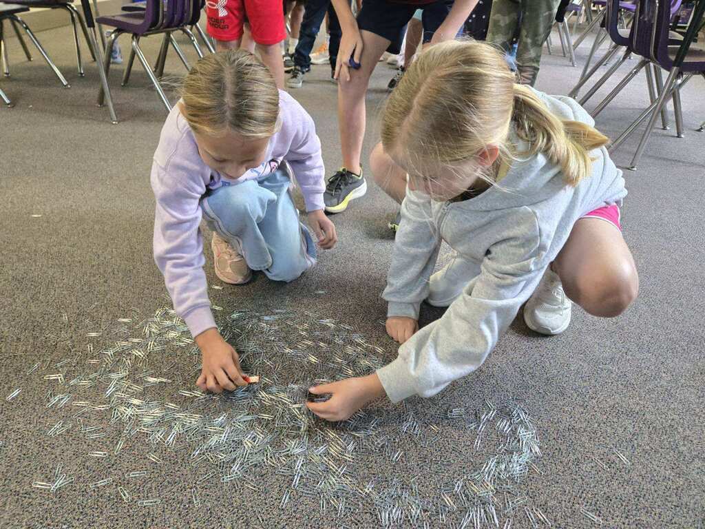 Ms. Brownell's science class uses different types of magnets to lift paper clips up from the floor.