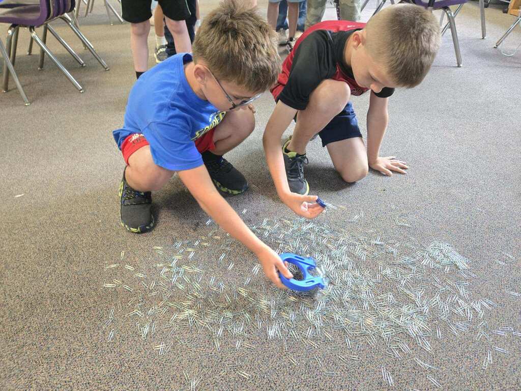 Ms. Brownell's science class uses different types of magnets to lift paper clips up from the floor.