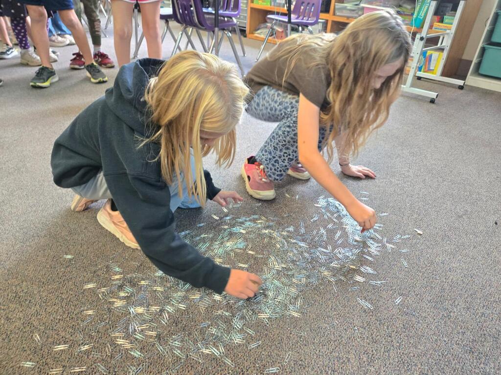 Ms. Brownell's science class uses different types of magnets to lift paper clips up from the floor.