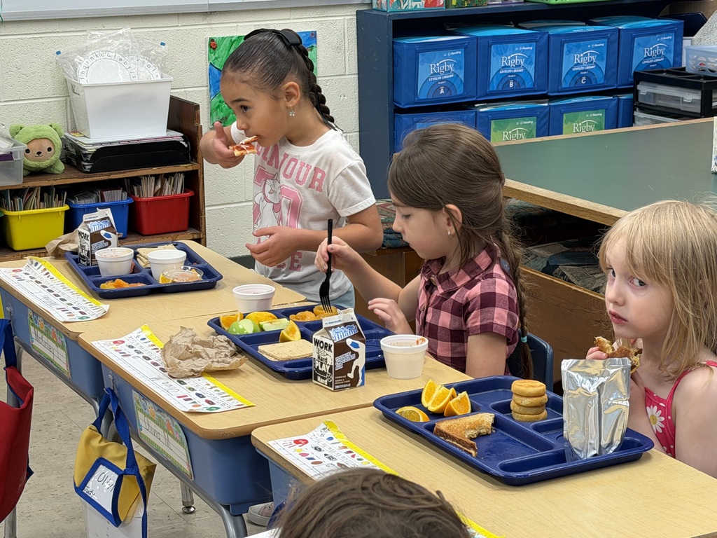 Mrs. Judy's kindergarten/first grade combo class eats lunch as Mrs.Orr, the Librarian at the Wakefield Public Library, and her Assistant, Mrs.Weir, reads to them.